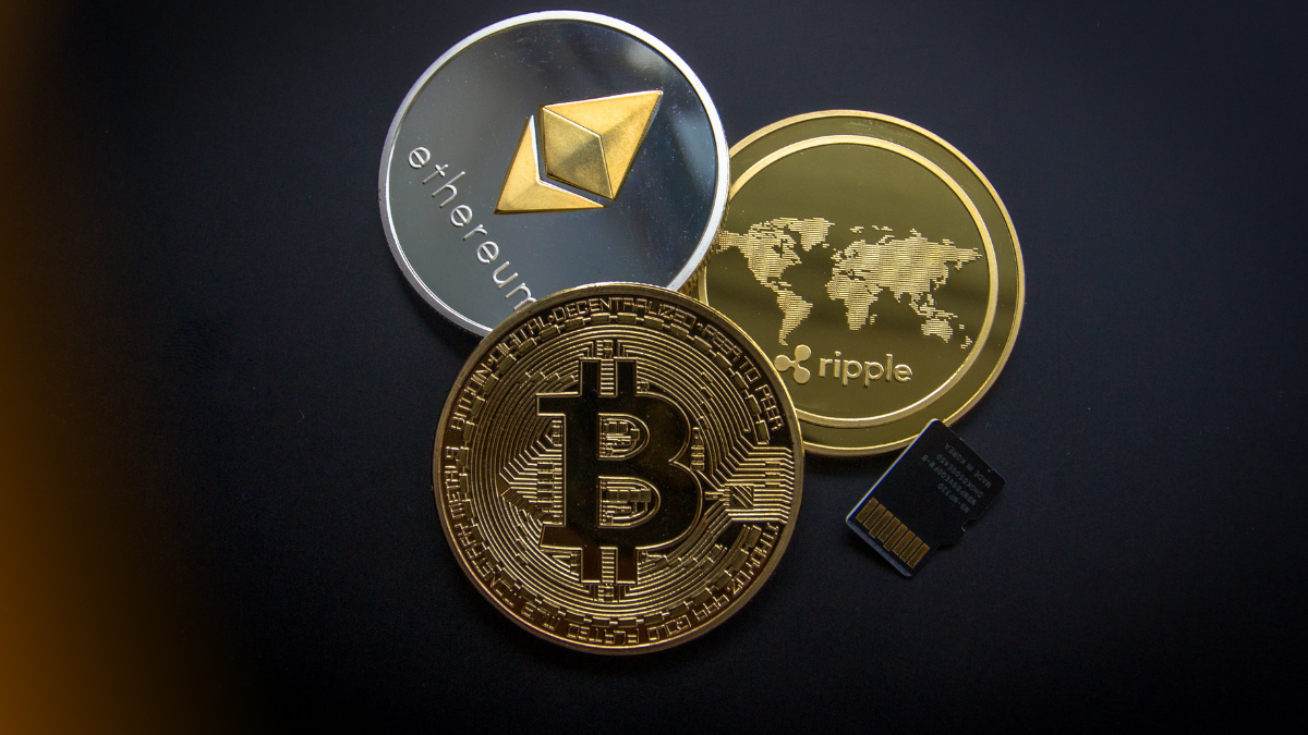 A close-up view of various cryptocurrency coins including Bitcoin, Ethereum, Ripple, Stellar, and Tron, showcasing colorful metallic designs under dynamic lighting.