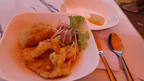 Ceviche peruano con papa rellena pagado con criptomonedas usando Lemon Cash. al costado su papa rellena y chicharrón de pota.
