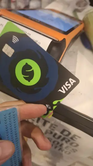 Tarjeta cripto Lemon siendo usada en terminal POS para pago sin contacto