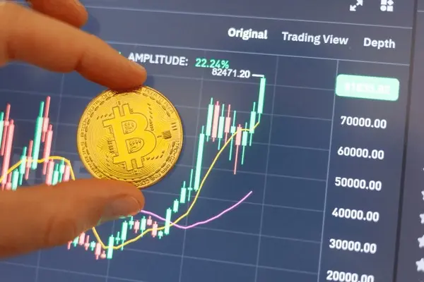 “Person sitting alone at a desk, gazing thoughtfully at a laptop displaying Bitcoin charts, reflecting quietly on emotions and market movement.”