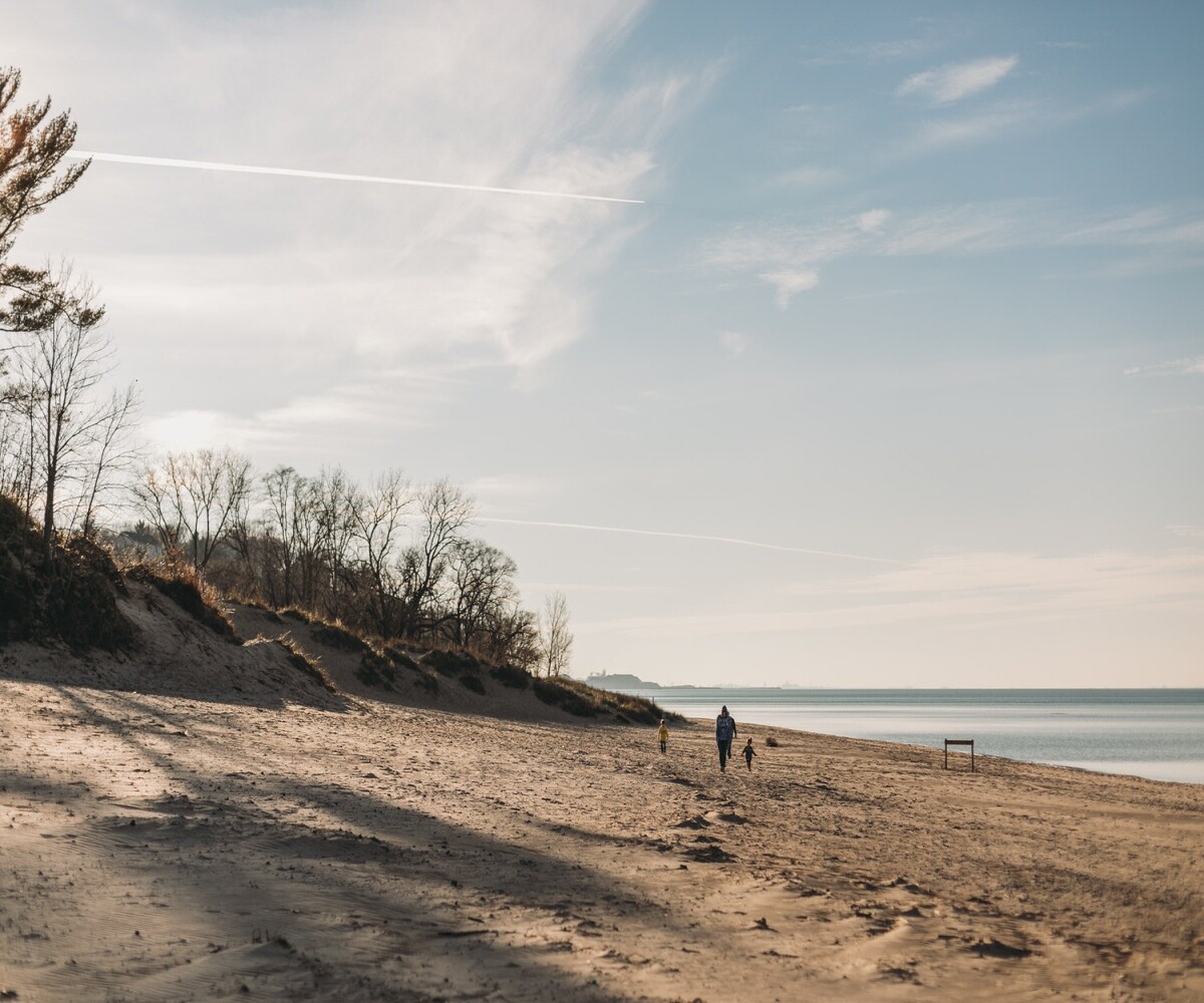 wide shot of person walking on beach at lake michigan