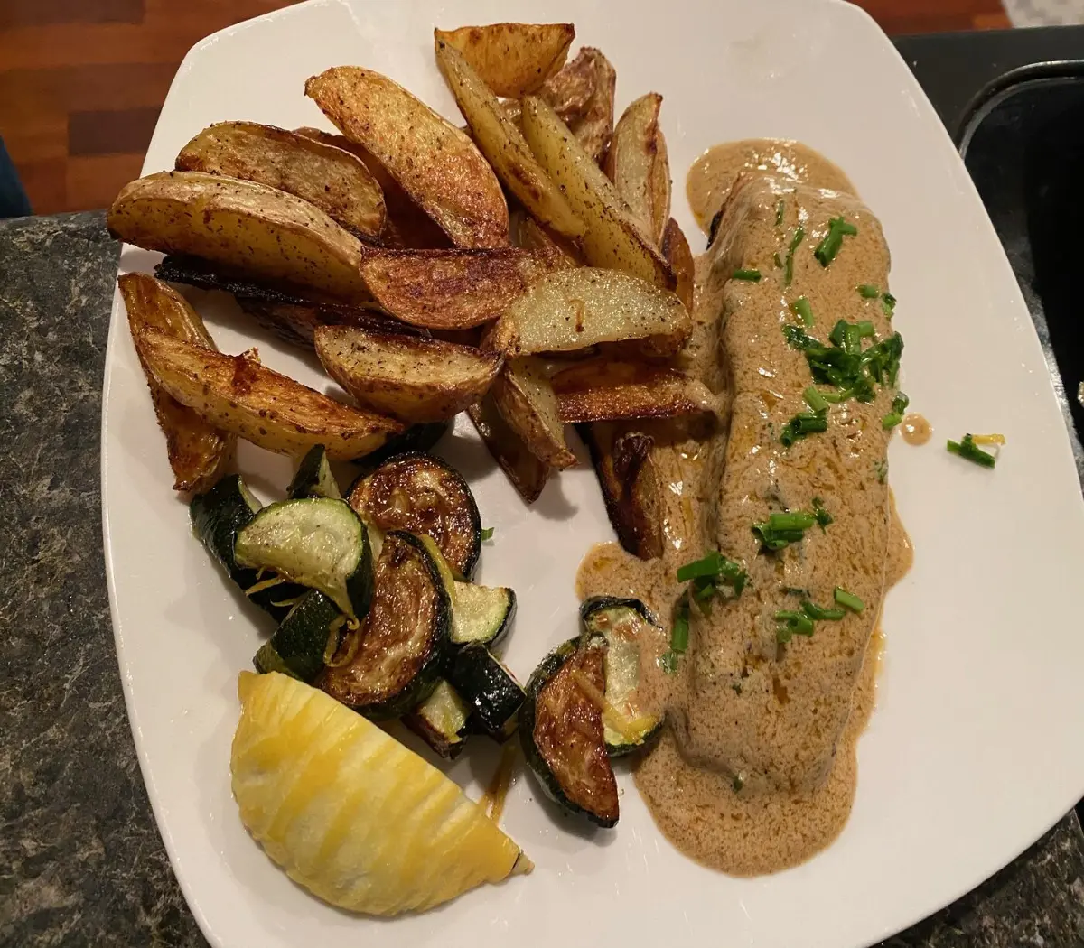 salmon in a buttery sauce with potatoes and zucchinis