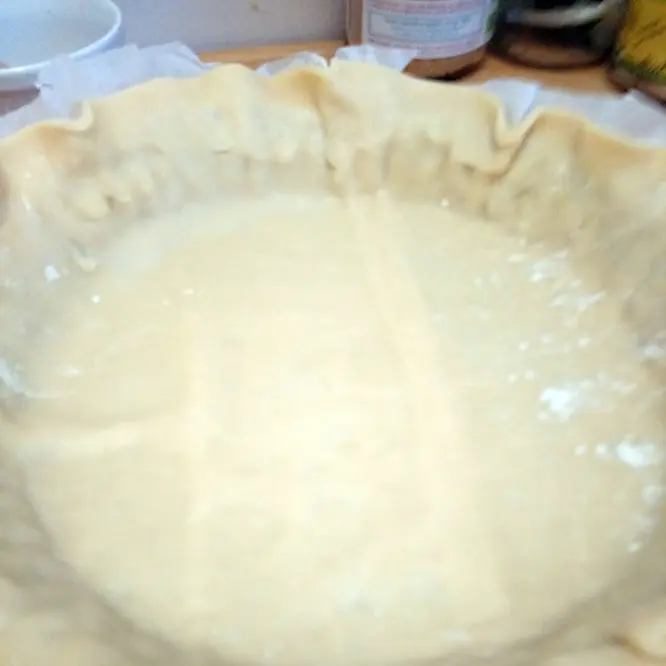 Spread the short pastry on a pie pan.