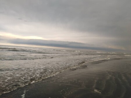 Run at the Beach Under Heavy Rain Next to Restless Waves