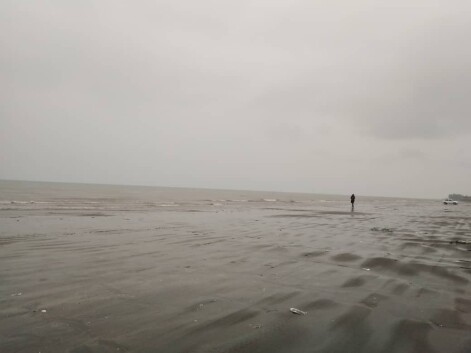 Run at the Beach Under Heavy Rain Next to Restless Waves