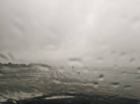 Run at the Beach Under Heavy Rain Next to Restless Waves