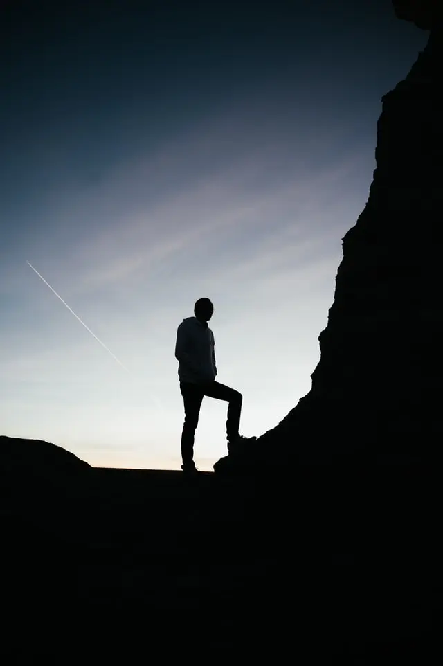 motivated person standing ready to climb a mountain