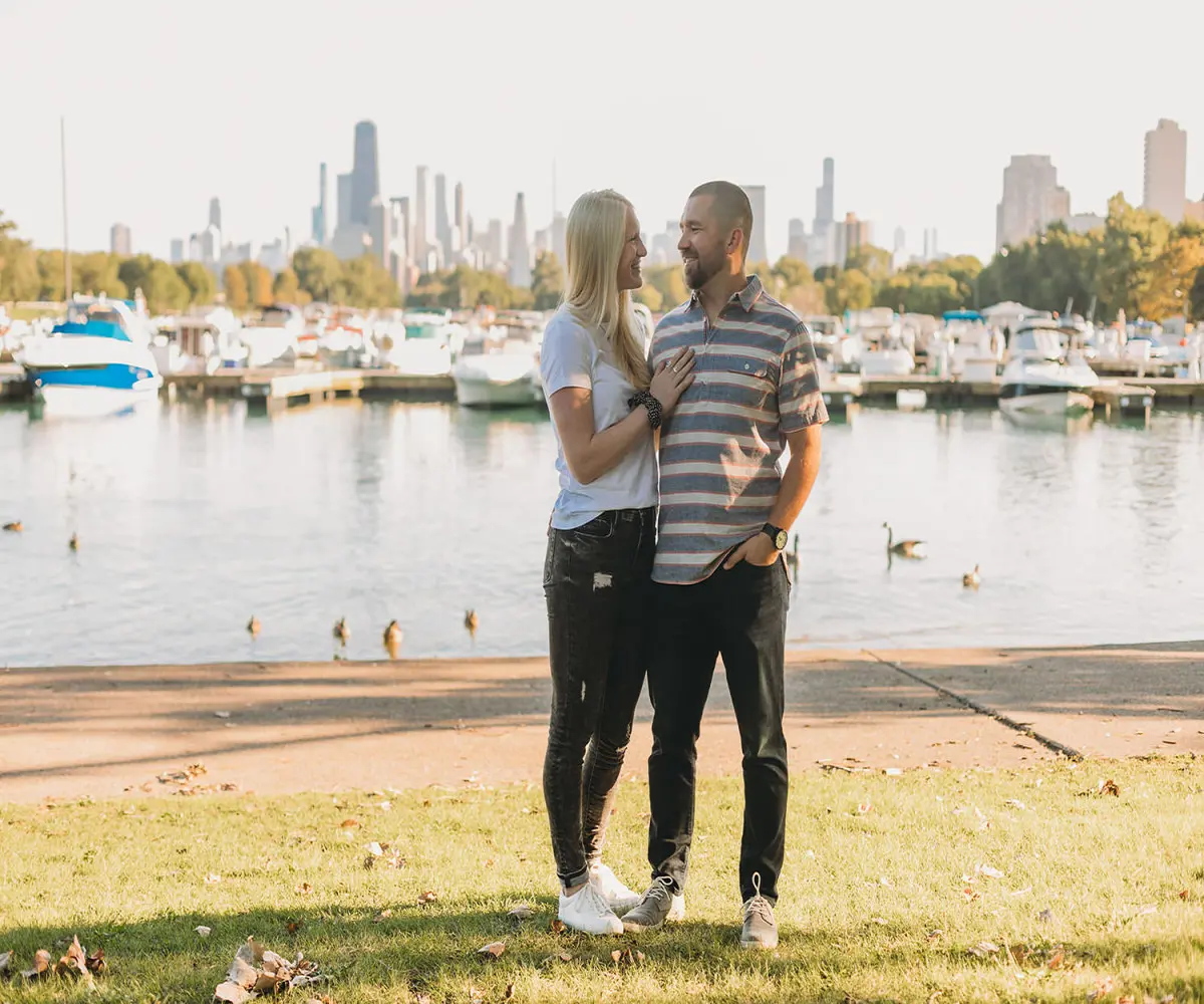 couple in chicago in front of harbor with skyline behind them