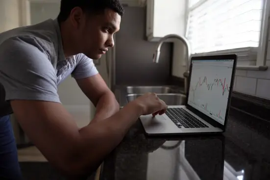 man trading cryptocurrency on laptop