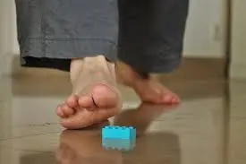 Stepping on a LEGO brick - Barefoot walking on top of a brick