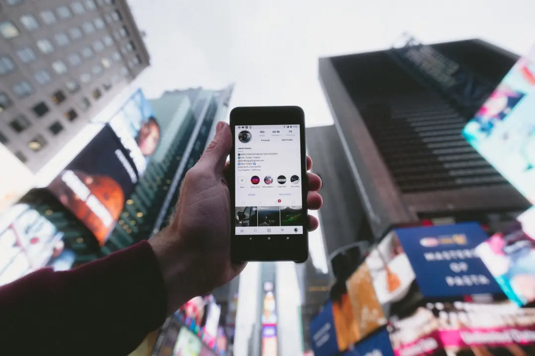 Person holding up phone, checking their Instagram profile