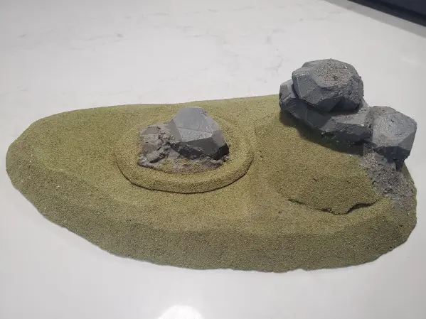 Large Hill with some rocks built on top of it combined with another rock